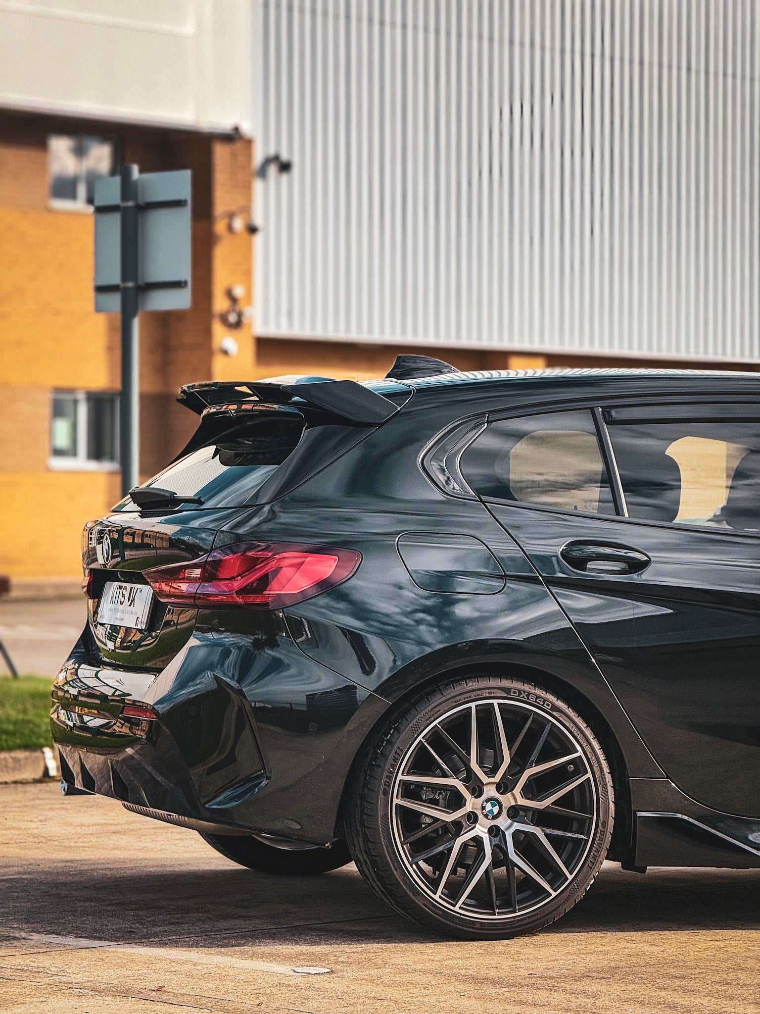 BMW F40 Gloss Black Body Kit installed on a sporty BMW hatchback, showcasing its sleek design and aggressive styling.
