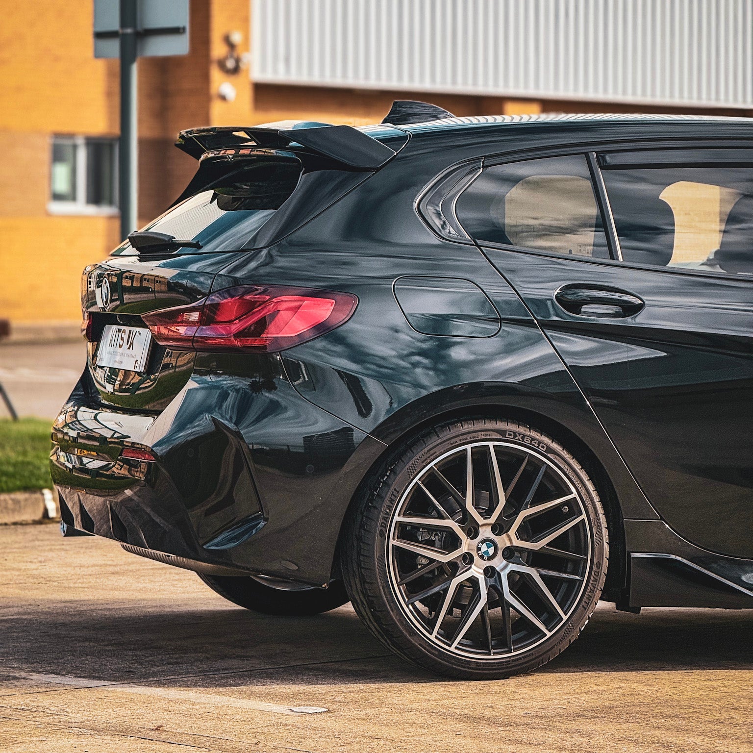 BMW F40 Gloss Black Body Kit installed on a sporty BMW hatchback, showcasing its sleek design and aggressive styling.
