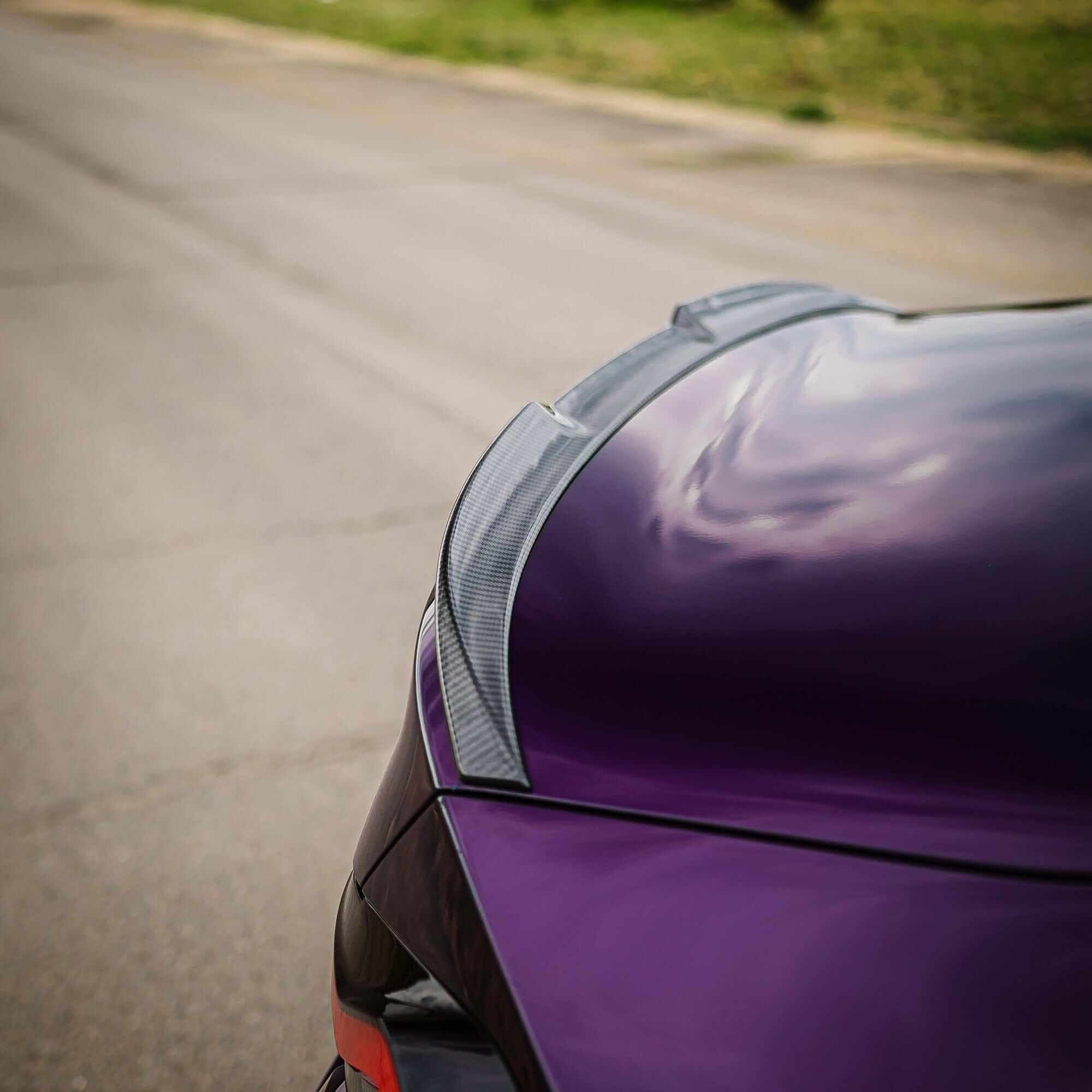 BMW G87 G42 Carbon Fibre Spoiler V2 on a purple car, showcasing modern and aggressive styling.