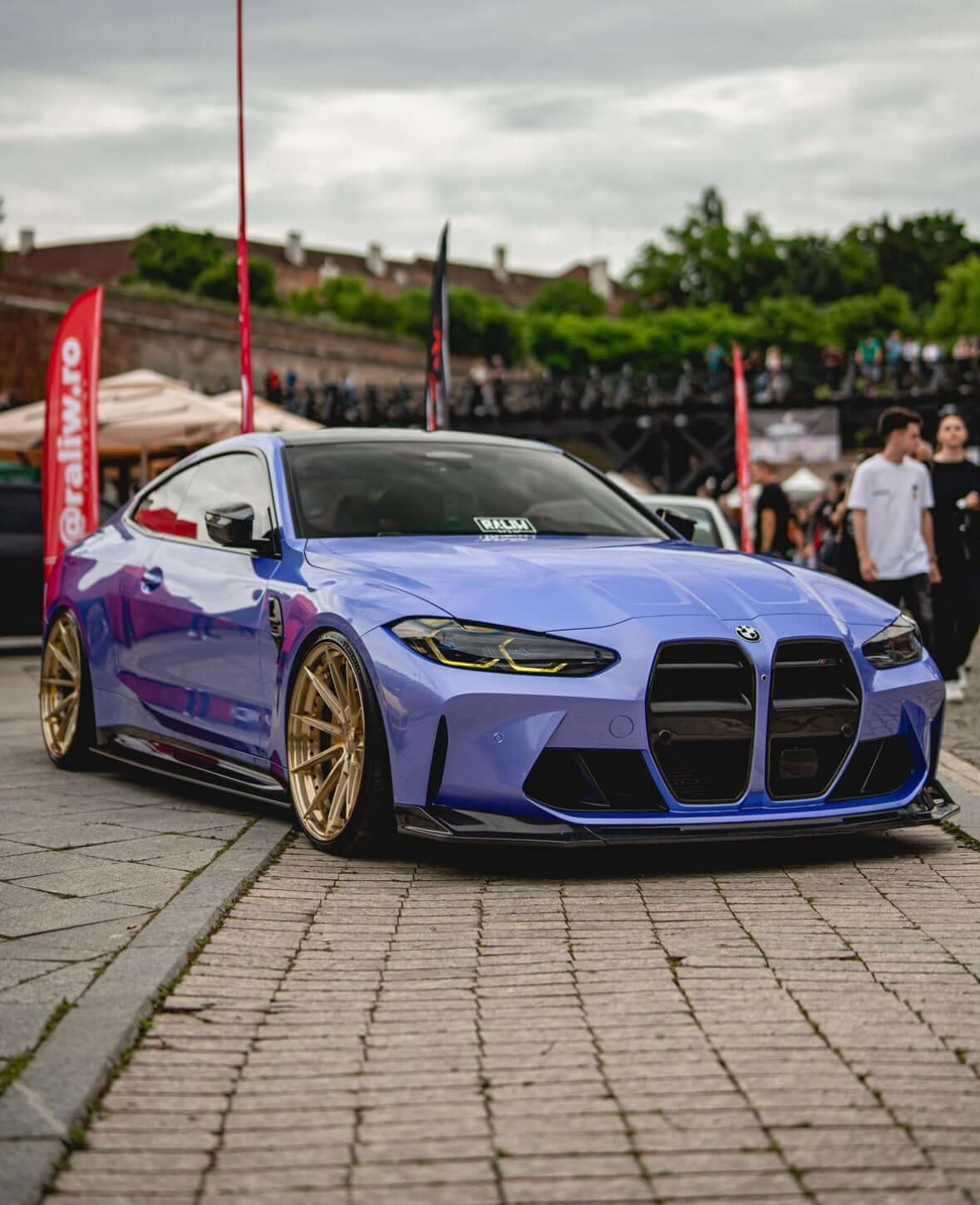BMW M3 M4 carbon fibre splitter - VS style on a customized purple BMW M3 at a car event.