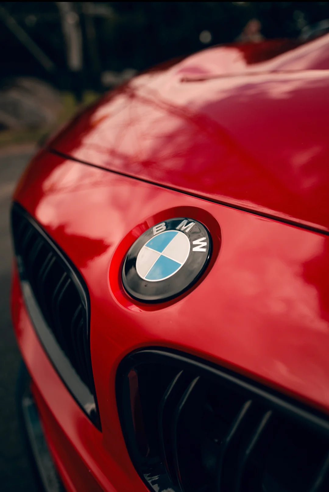 BMW Dechromed Roundels on a red BMW vehicle, showcasing the premium black badge upgrade.