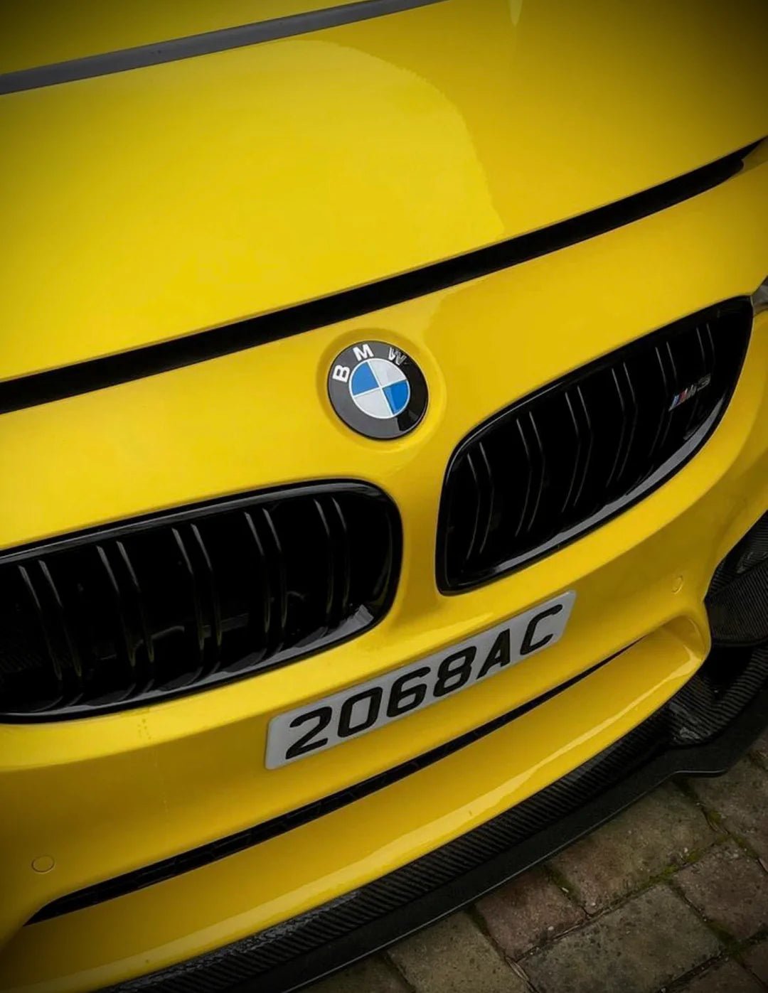 BMW Dechromed Roundels on a yellow BMW car, showcasing an aggressive styling upgrade.