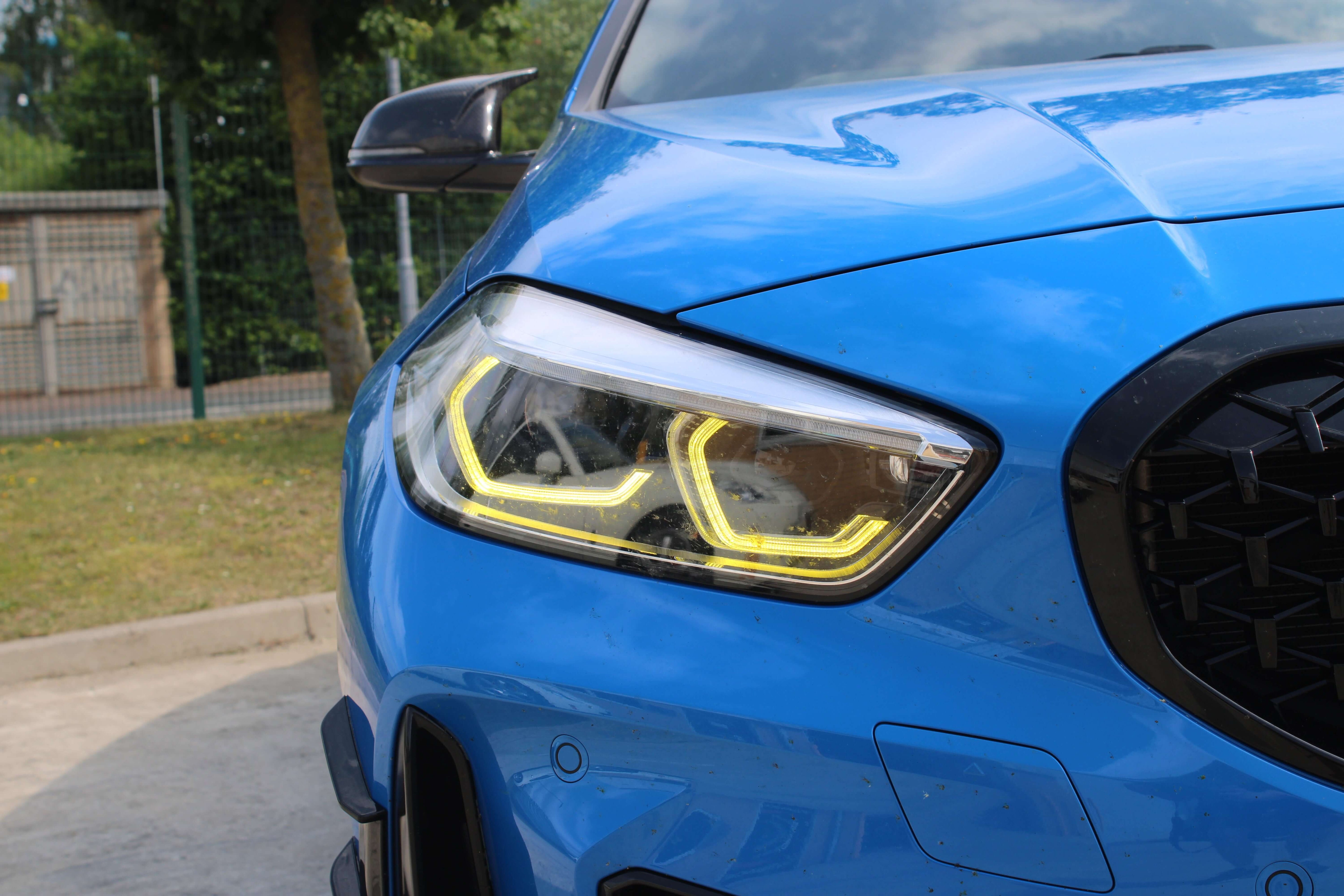 BMW Yellow DRL Modules showcased on a blue BMW car, featuring bright yellow daytime running lights.