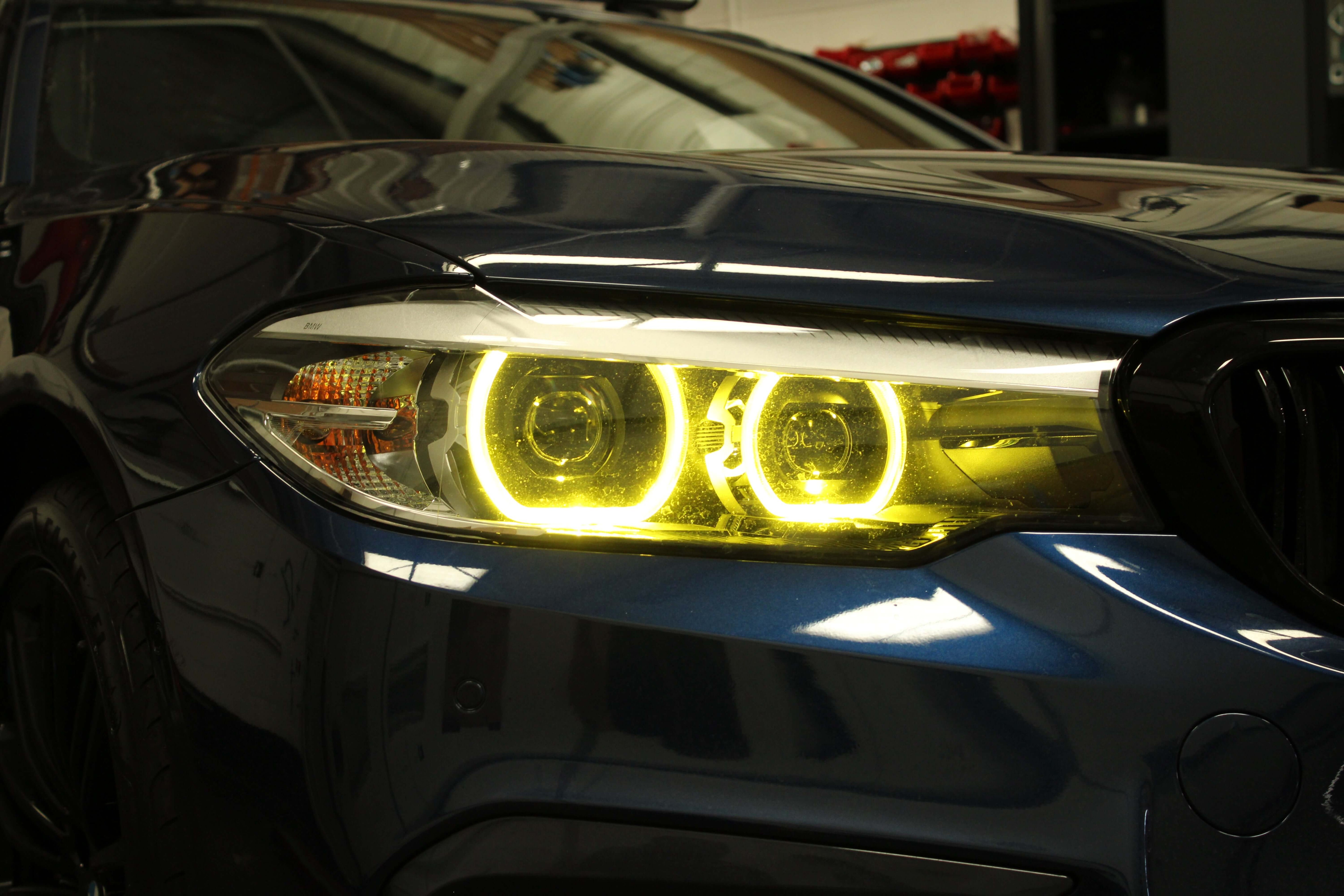 BMW yellow DRLs illuminating with a vibrant yellow glow, highlighting the design and functionality.