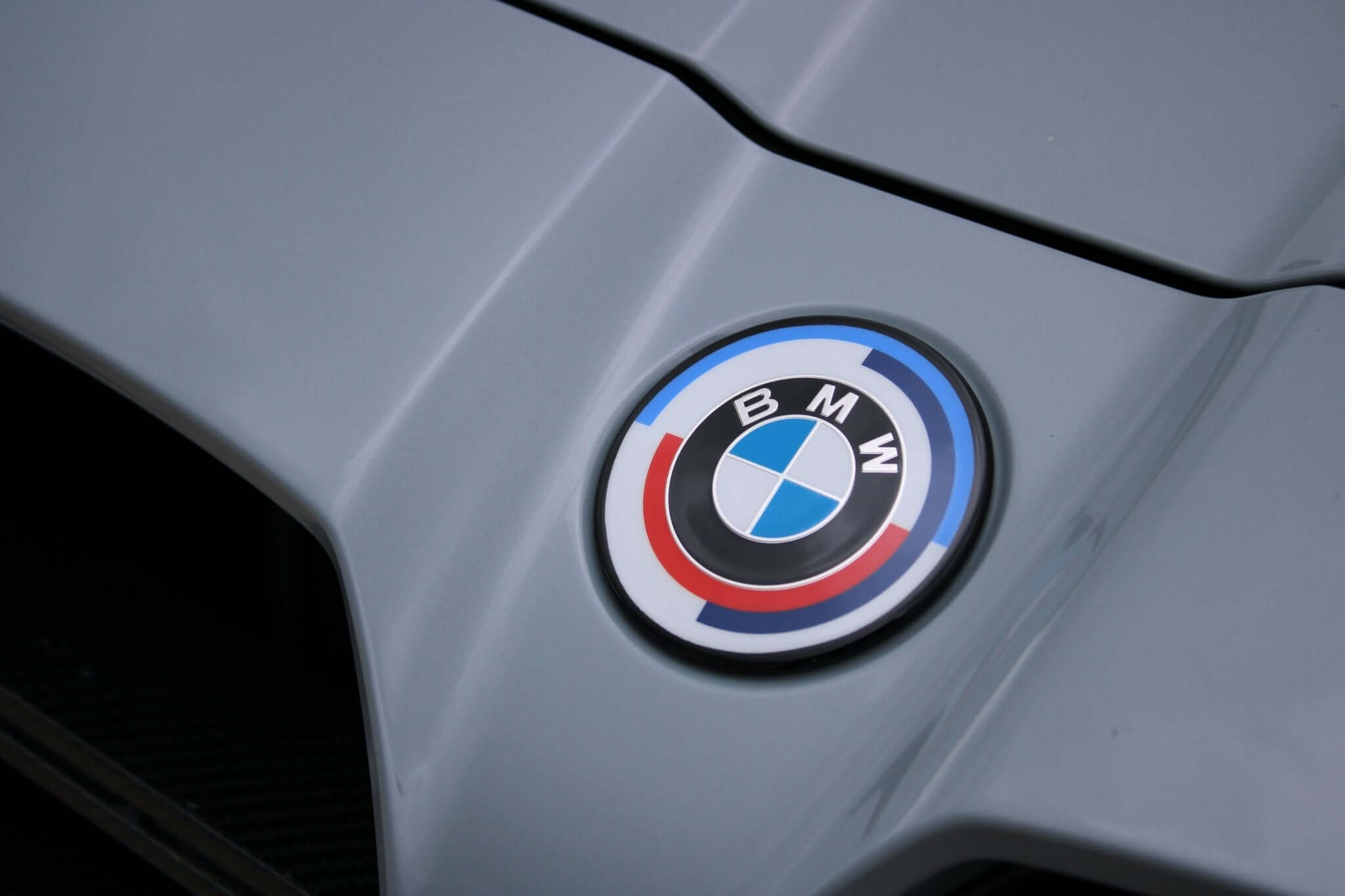 dechromed BMW G series roundels on a BMW car hood, showcasing an aggressive and sleek look.