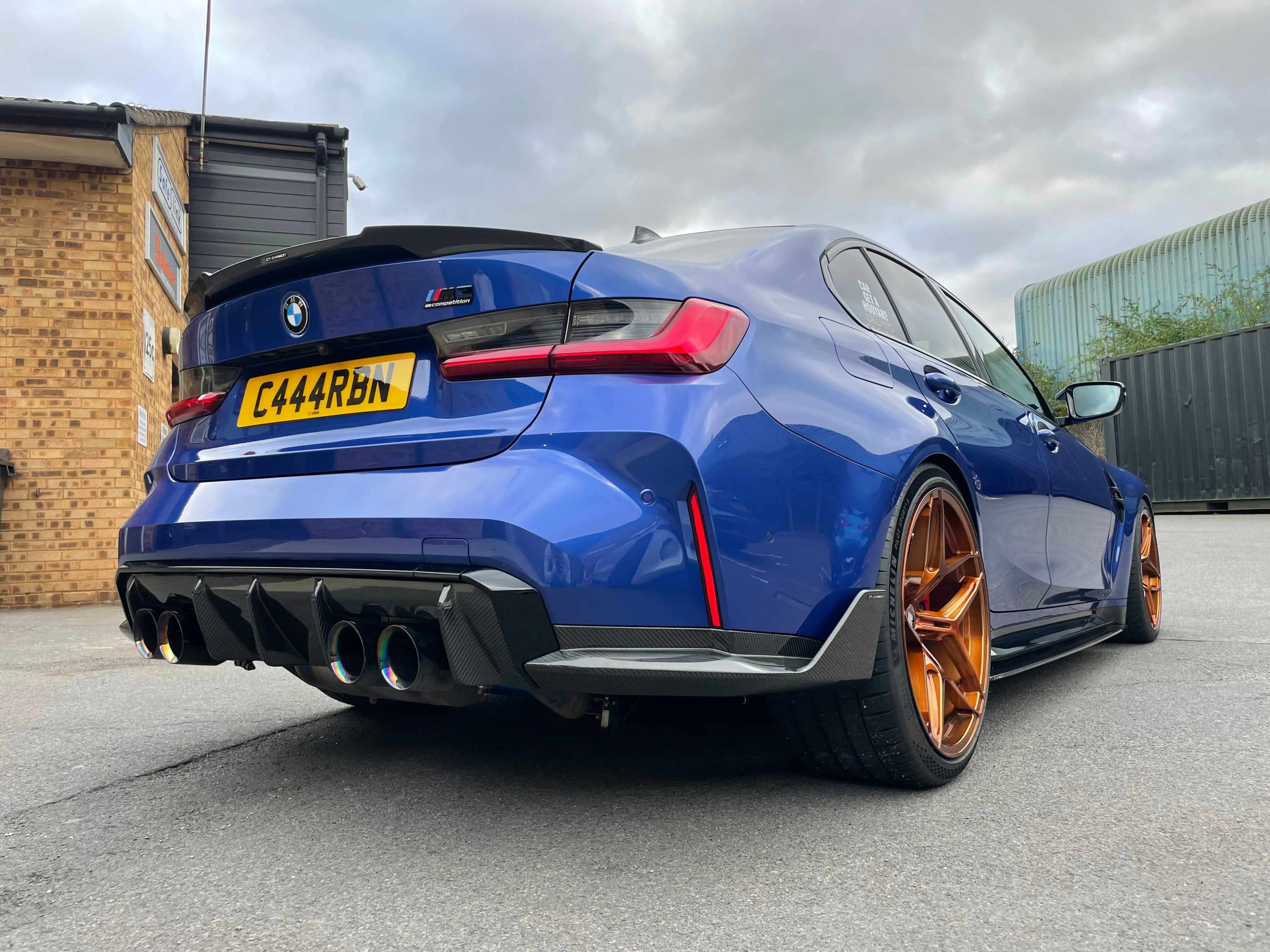 BMW G80 M3 FULL CARBON FIBRE KIT - MP STYLE showcased on a blue BMW M3 with carbon rear diffuser and stylish wheels.