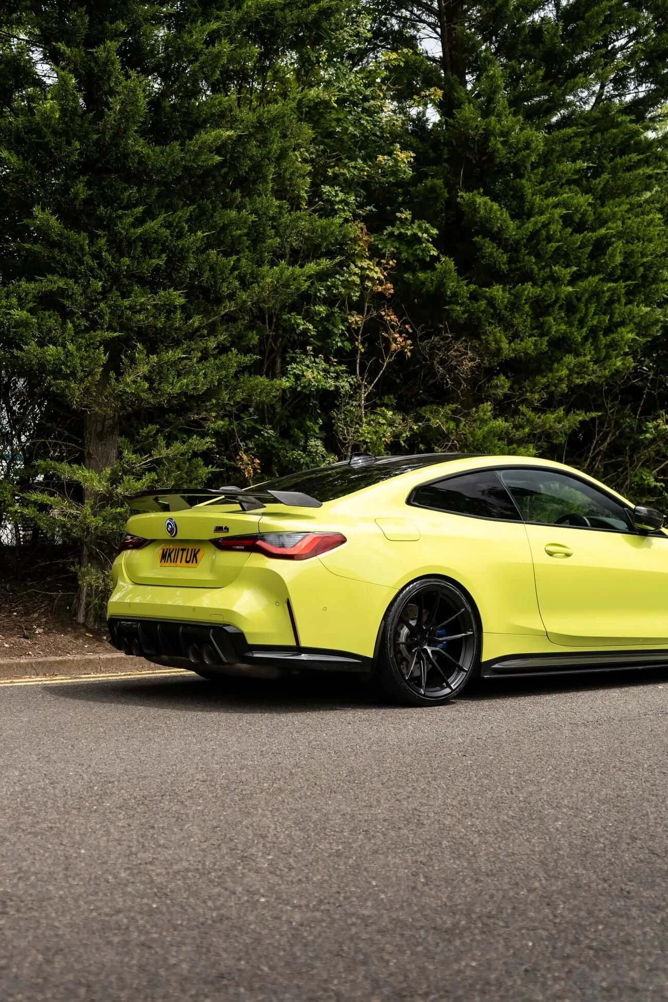BMW M4 G82/G83, Motech Stance Lowering Spring Kit showcased on a vibrant yellow coupe parked amidst greenery.