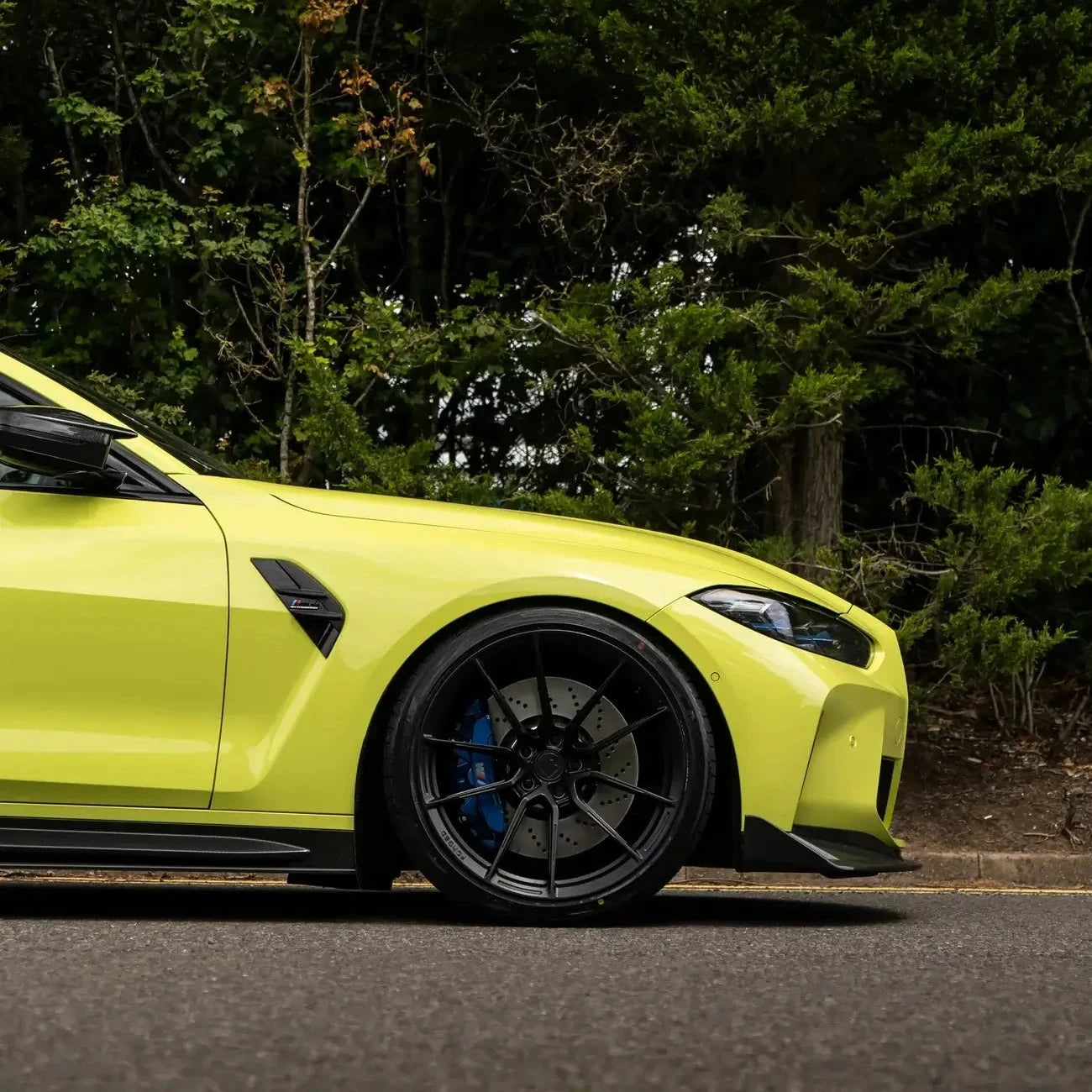 BMW M4 G82/G83 with Motech Stance Lowering Spring Kit showcasing a sleek lowered profile near trees.