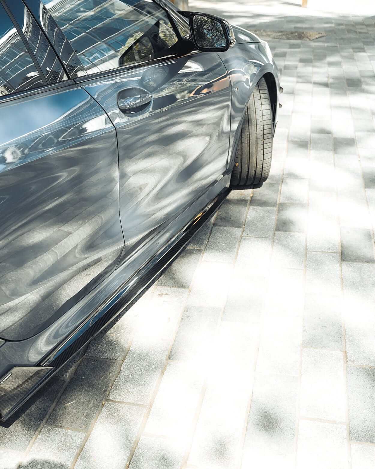 BMW F40 Carbon full body kit showcased on a parked vehicle, highlighting sleek design and aggressive stance.
