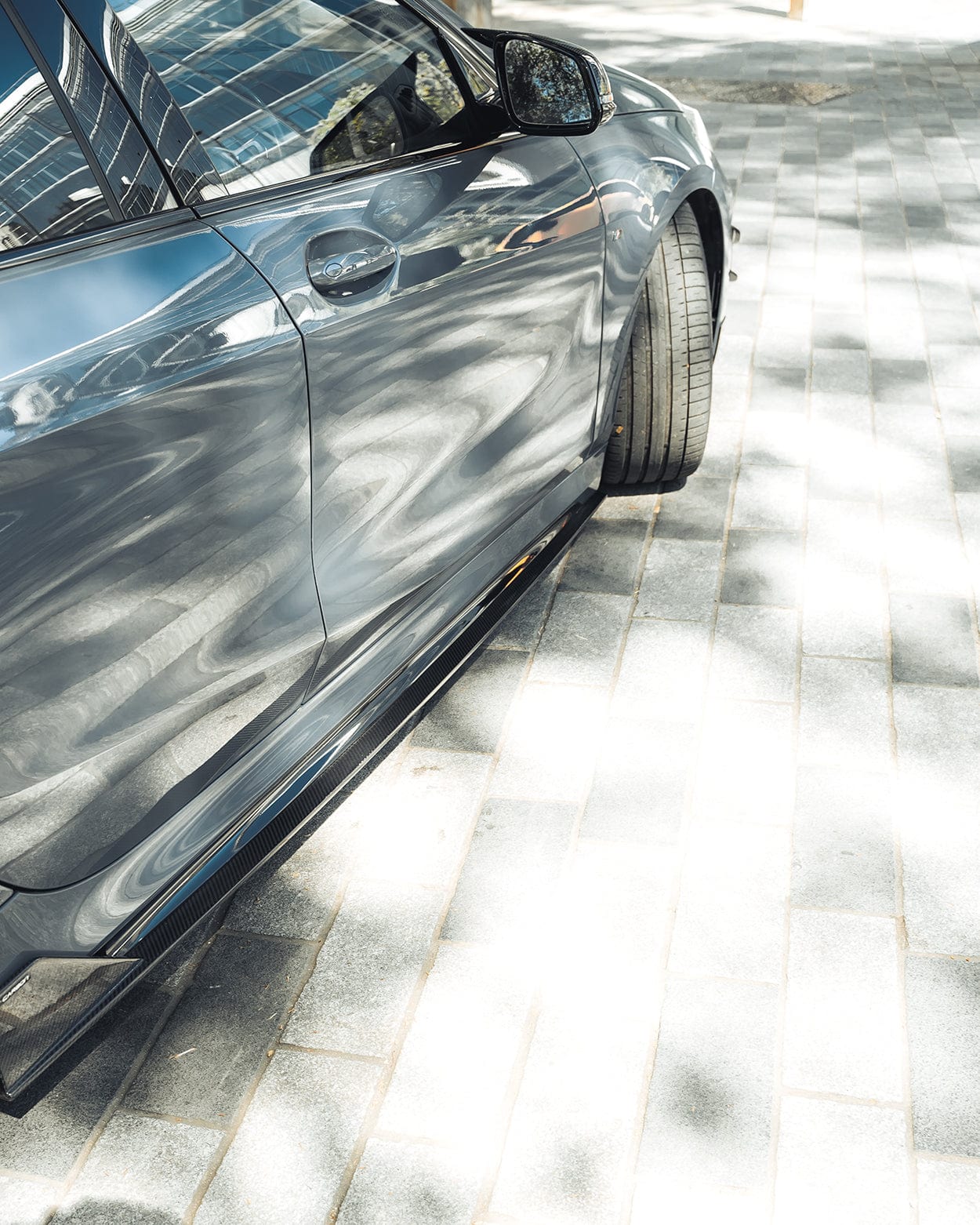 BMW F40 Carbon full body kit showcased on a parked vehicle, highlighting sleek design and aggressive stance.