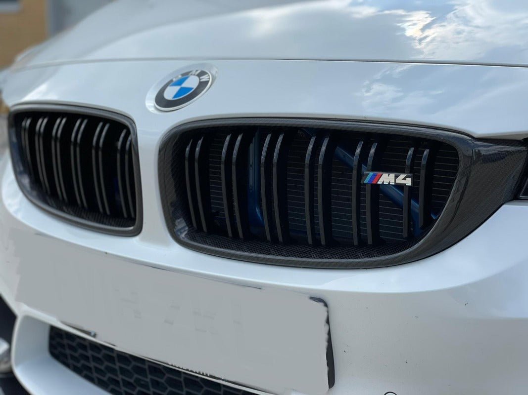 BMW F80 F82 F32 Carbon Fibre Kidney Grilles installed on a white BMW vehicle for aggressive styling.