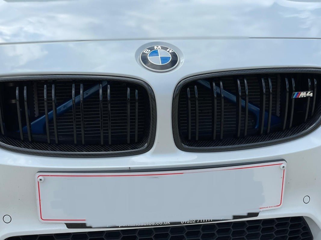 BMW F80 F82 F32 Carbon Fibre Kidney Grilles showcasing M3 M4 style on a white BMW vehicle.