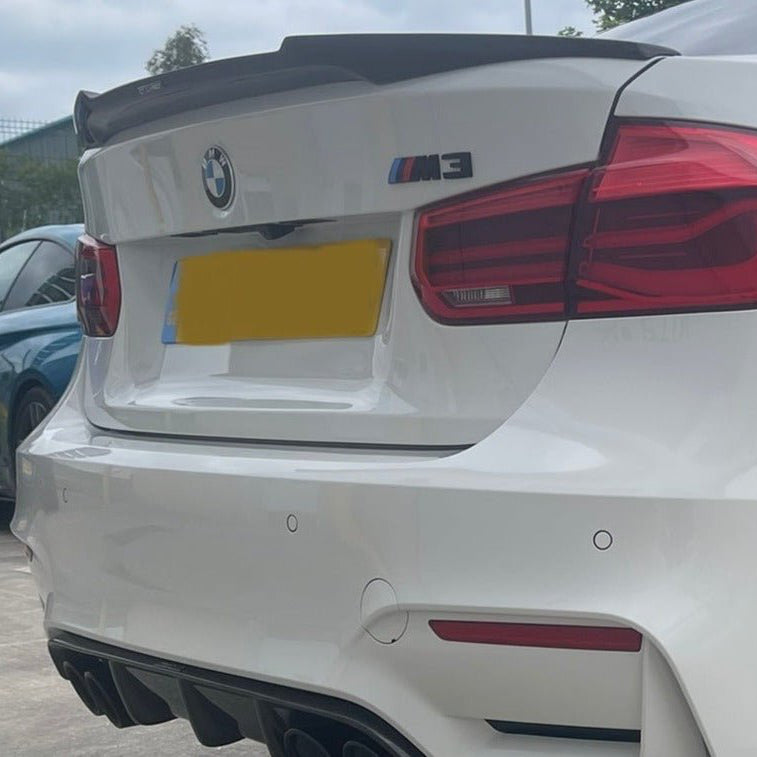 BMW F80 F30 Carbon Fibre V Style Spoiler on a white BMW M3, showcasing an aggressive rear design with a sporty look.