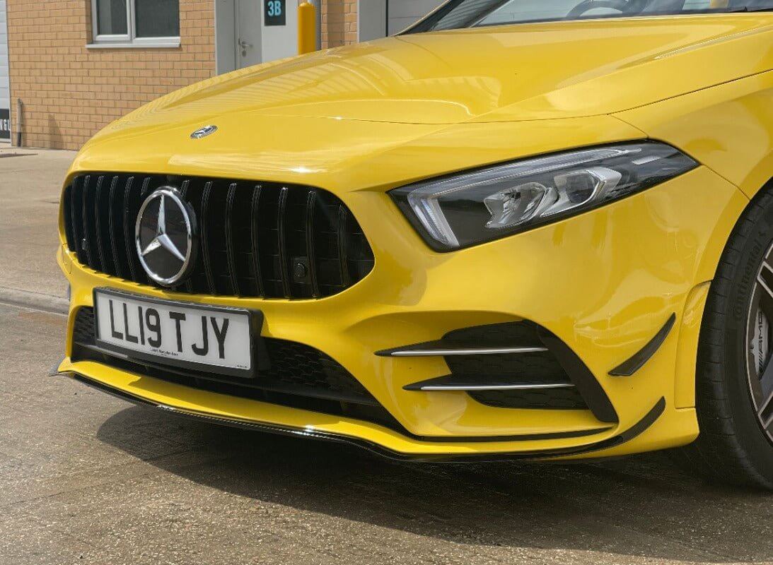 Mercedes Benz A35 aero package showcased on a bright yellow Mercedes Benz A35, highlighting the front details and grille.