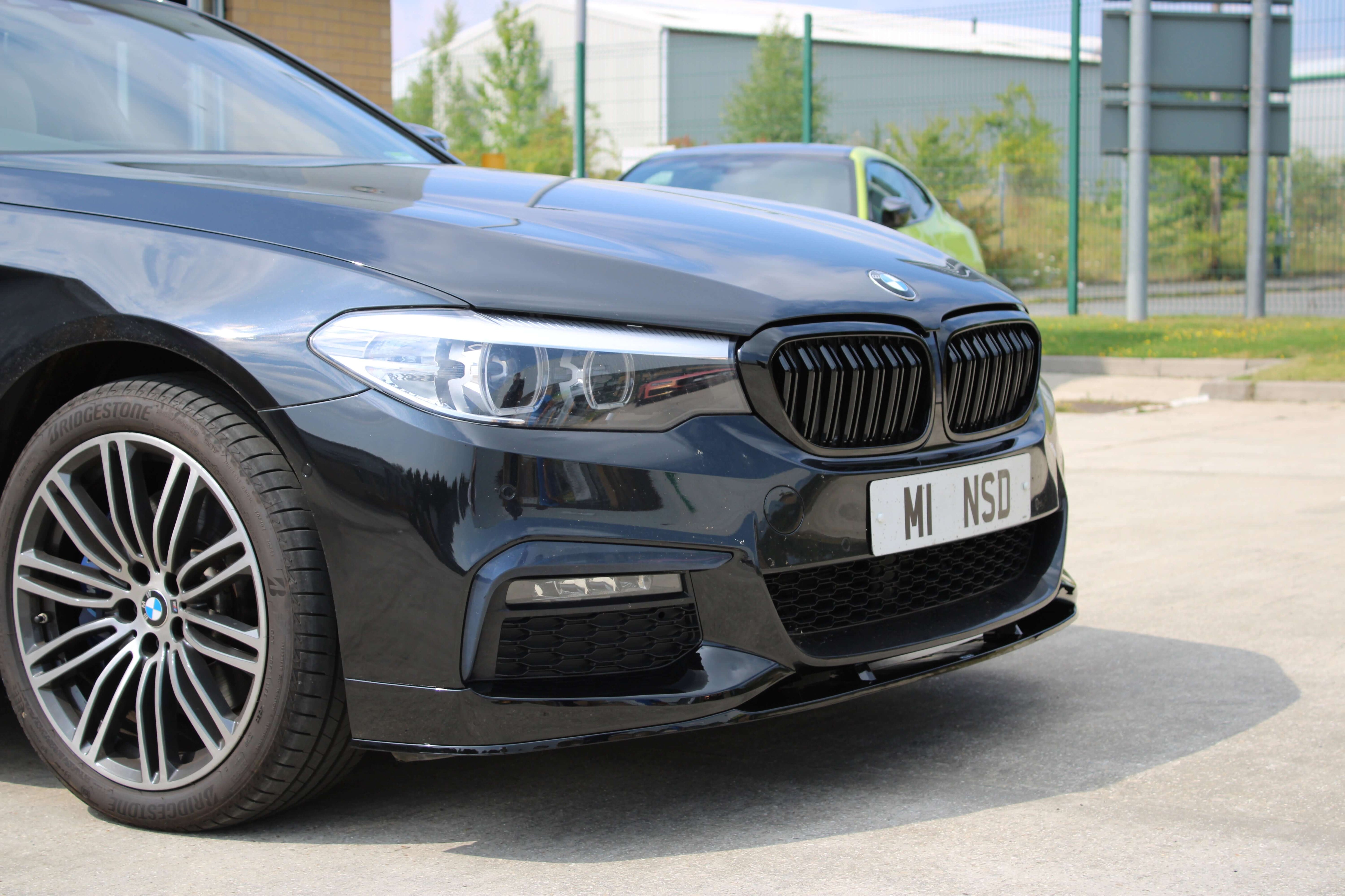 BMW G30 G31 Front Splitter installed on a black BMW car, showcasing an aggressive front lip design.