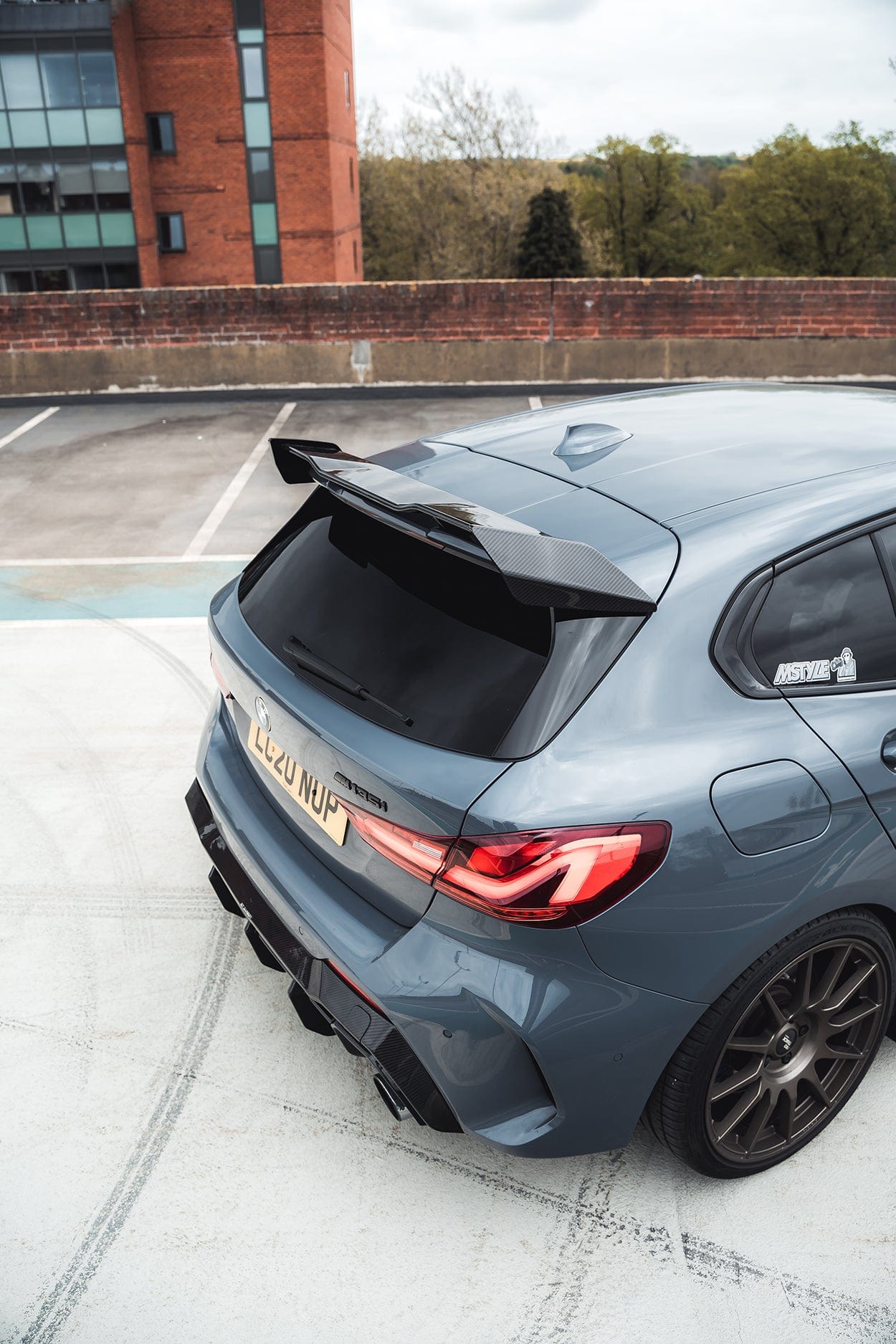 BMW F40 Carbon full body kit featuring aggressive rear diffuser and stylish rear wing on a gray BMW 1 Series.