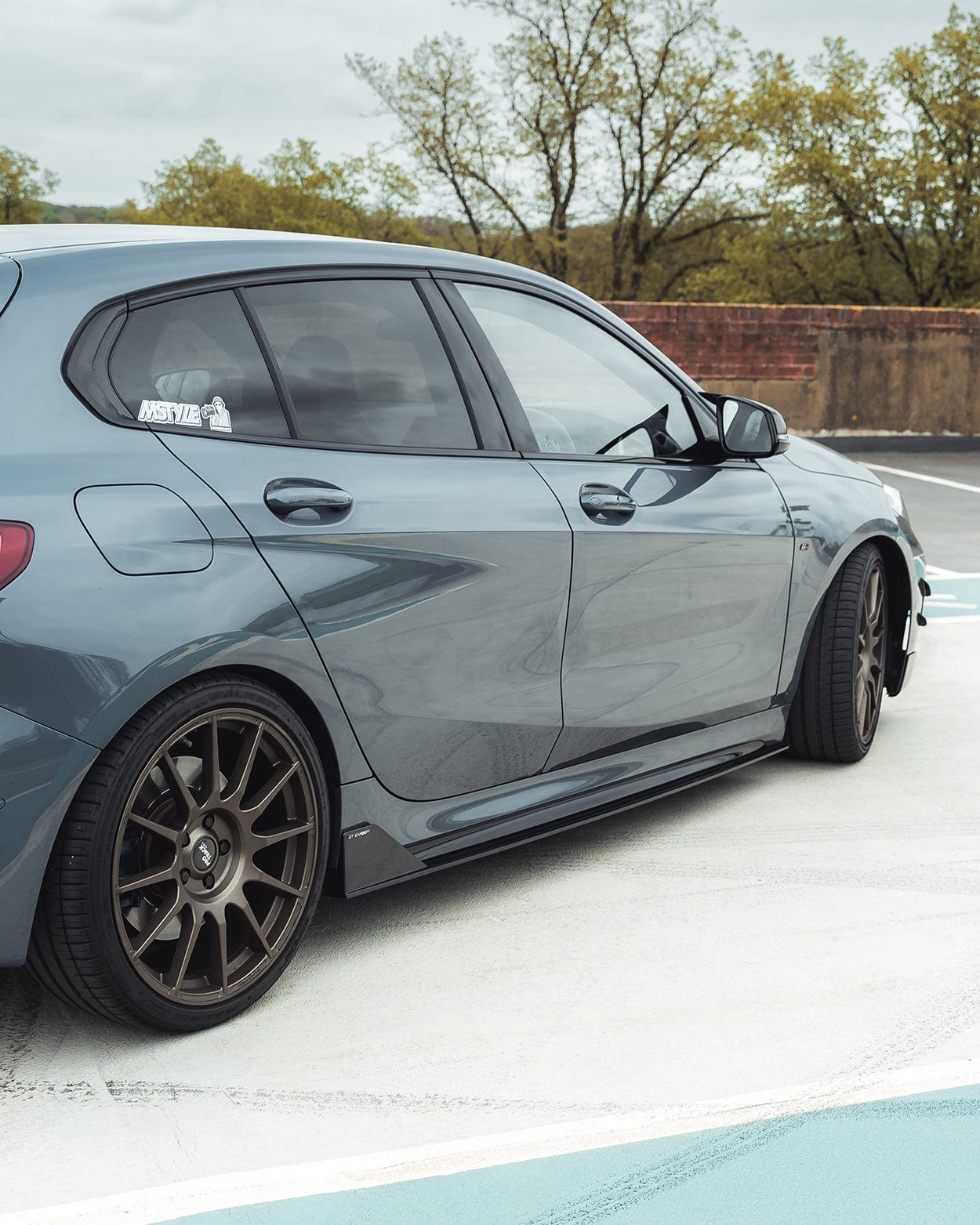 BMW F40 Carbon full body kit showcasing sleek design and aggressive stance in a stylish dark grey color.