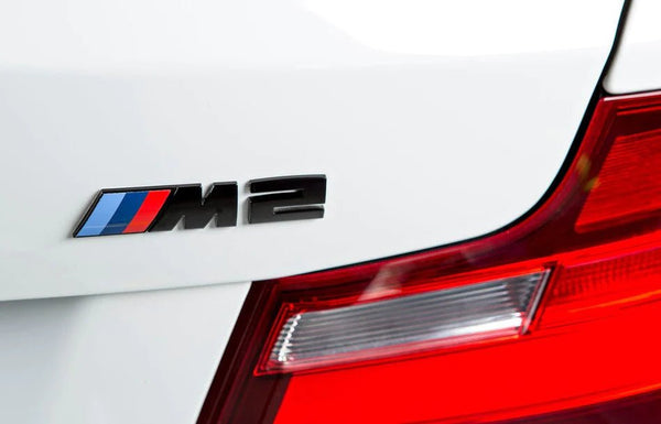BMW M2 Black Tailgate Badge on a white BMW, showcasing premium exterior styling upgrade.